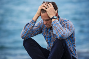 Upset man holding head in hands