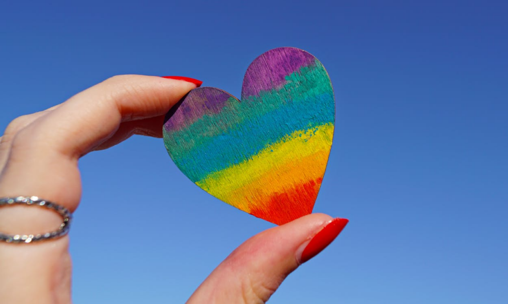 Valentine heart with pride colors held in hand