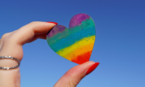 Valentine heart with pride colors held in hand