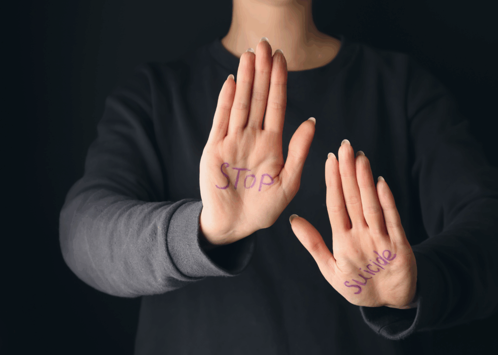 Person in sweater showing palms with writing on them