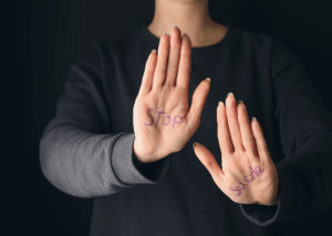 Person in sweater showing palms with writing on them