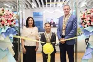 Three people at a ribbon cutting ceremony.