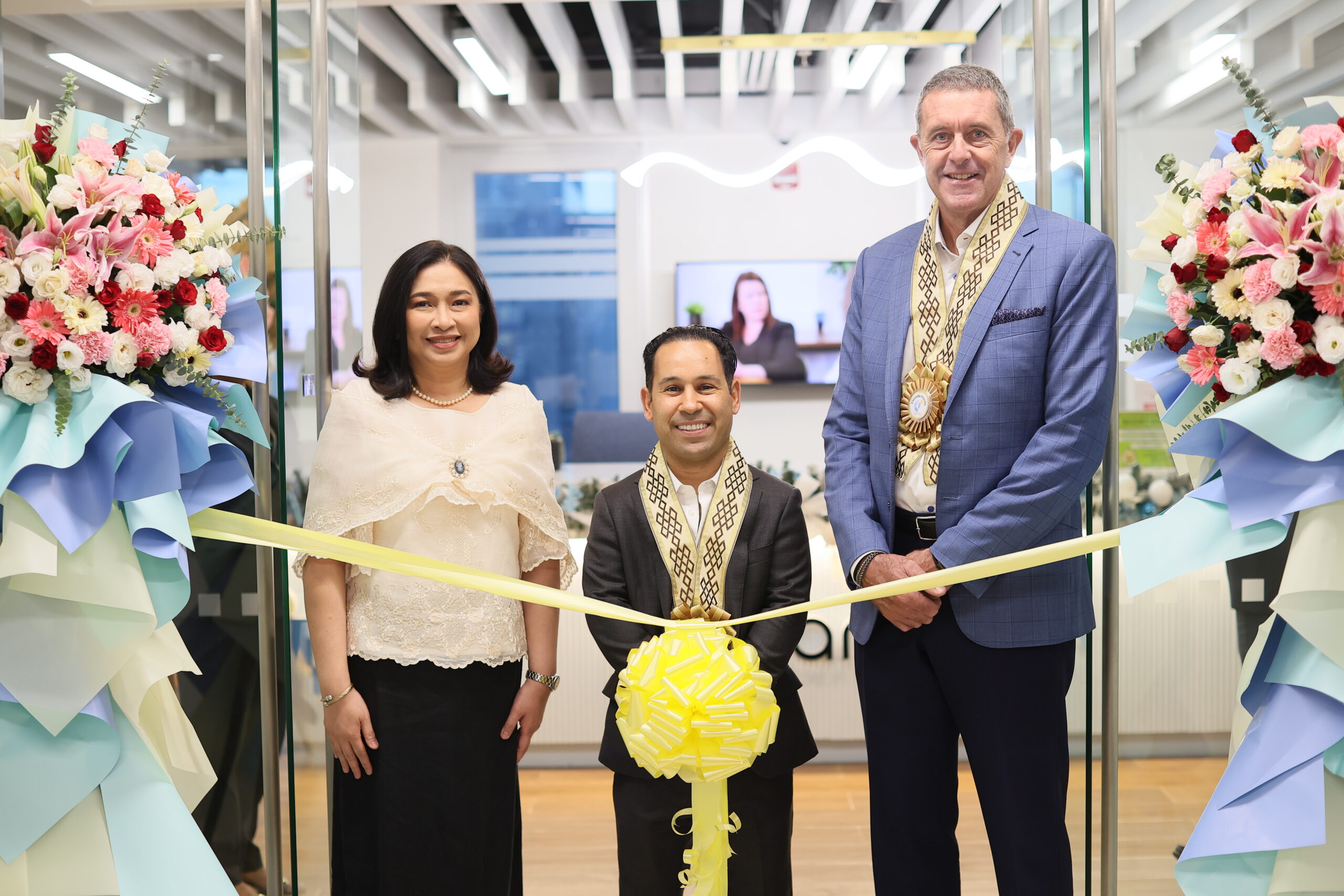 Three people at a ribbon cutting ceremony.